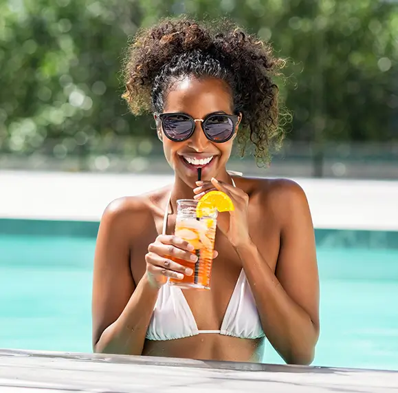 woman enjoying a drink in the pool